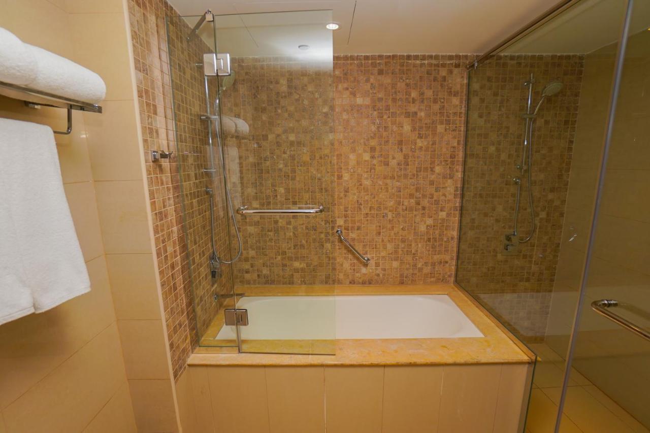The Grand Lux Hotel Doha Exteriör bild A bathtub with a shower enclosure